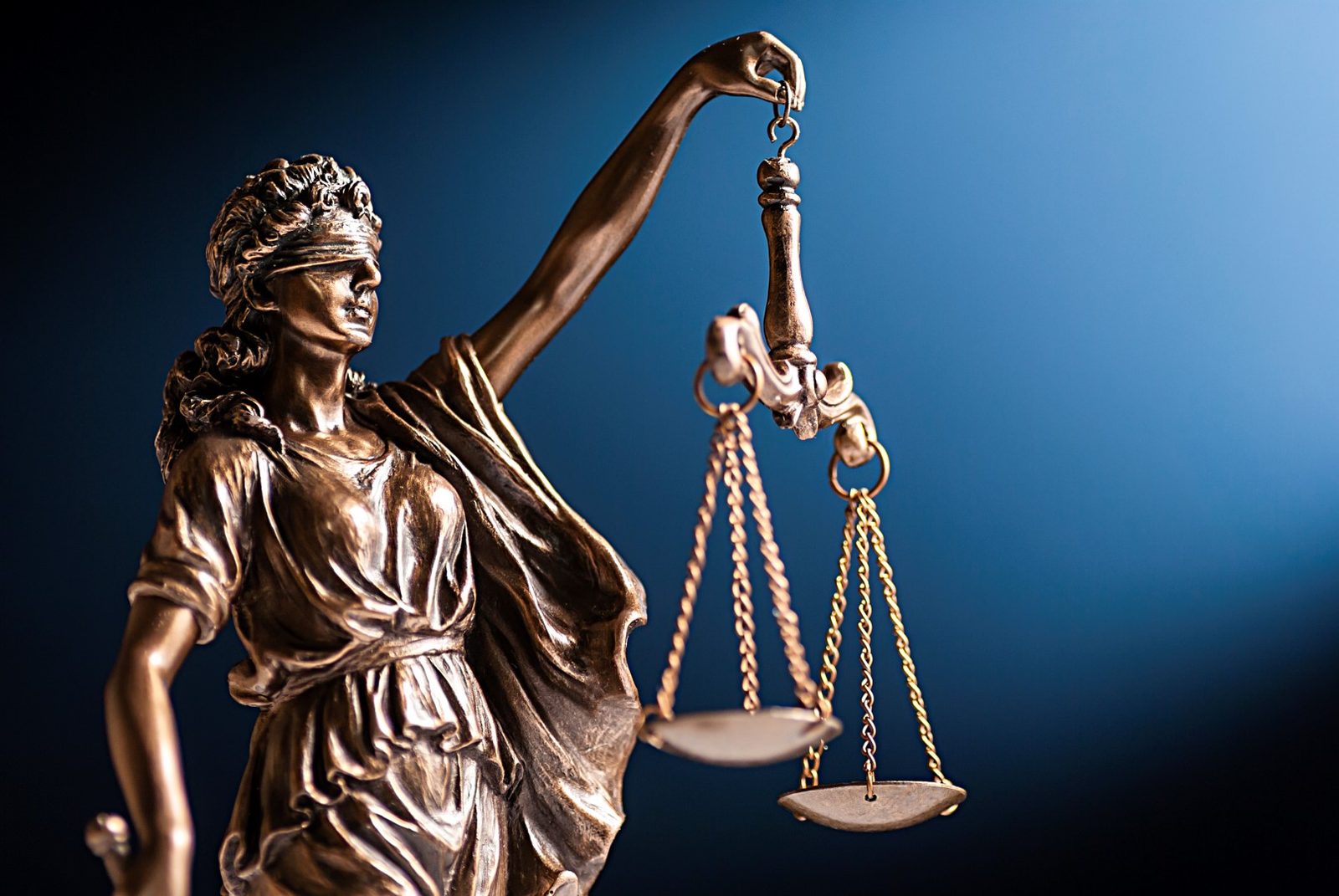 A bronze figurine of Lady Justice holding her scales, representing legal investigations in Little Rock