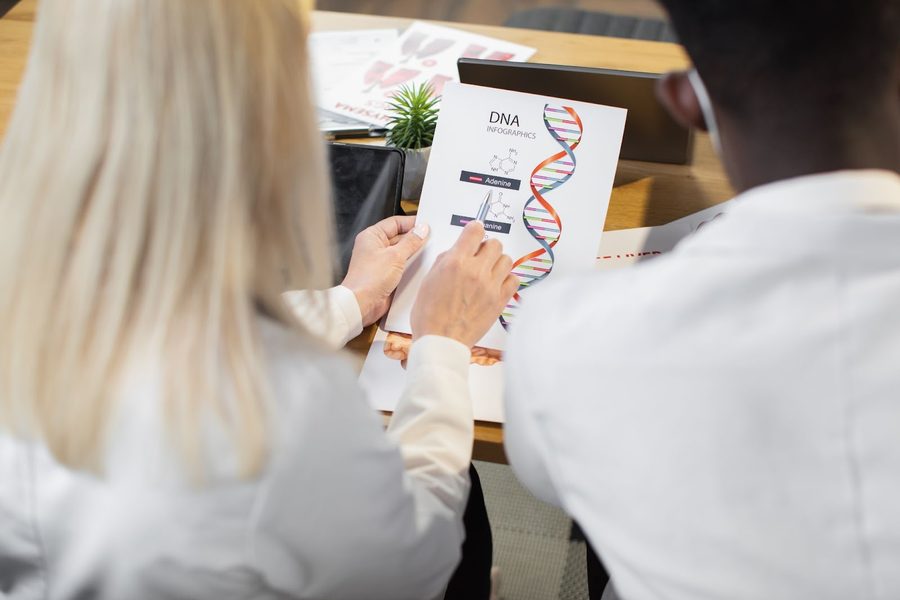 Multiracial genetic scientists discussing DNA modification and gene engineering.