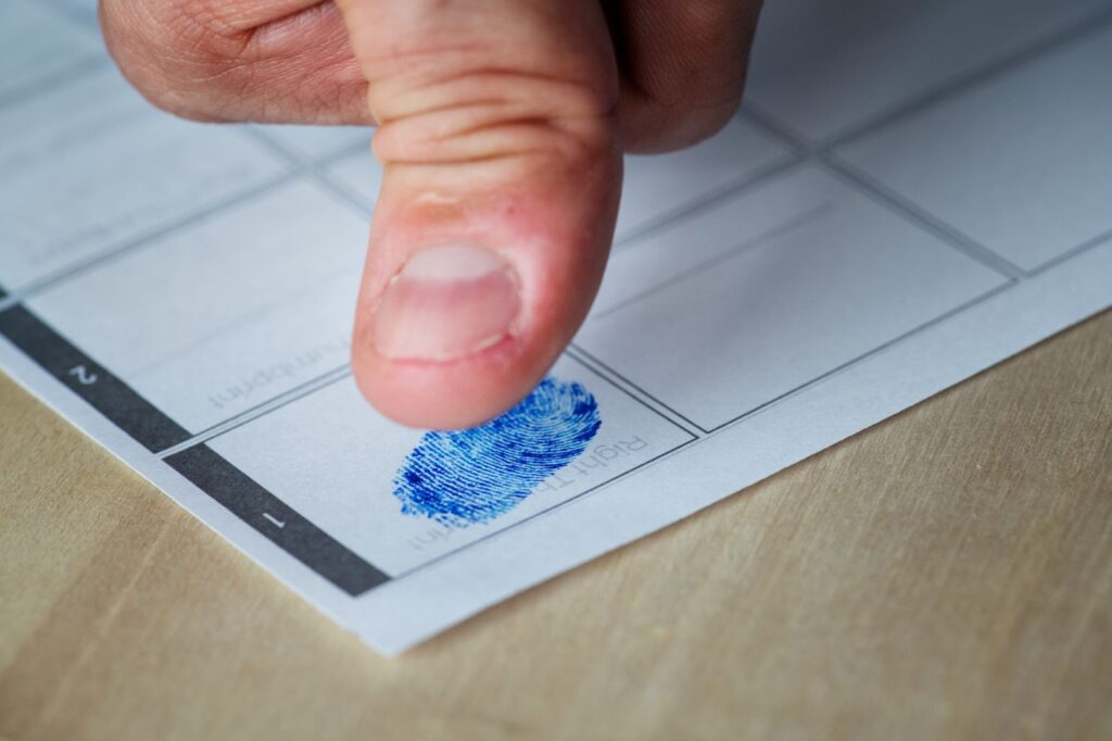 A closeup of a thumb fingerprint on paper with ink.