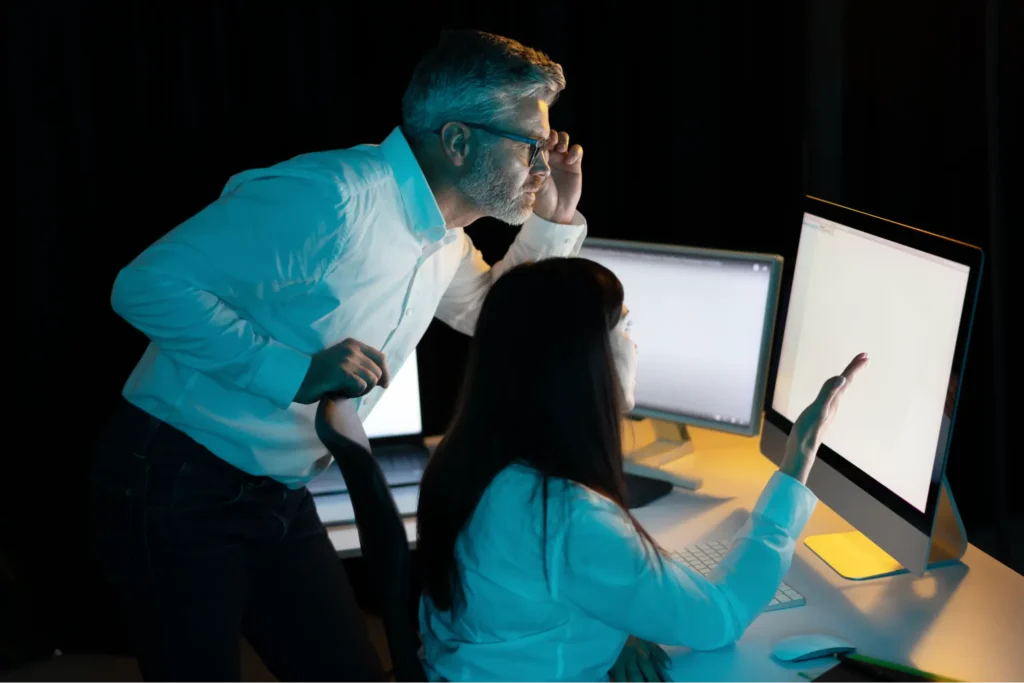 A man and a woman looking at a computer screen.