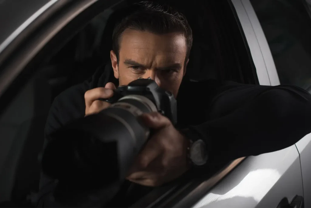 A private investigator taking a picture from his car.